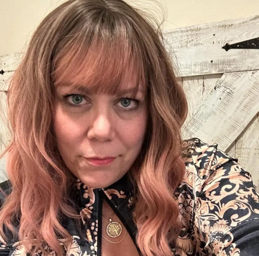 Short wavy pink synthetic wig with dark roots and bangs