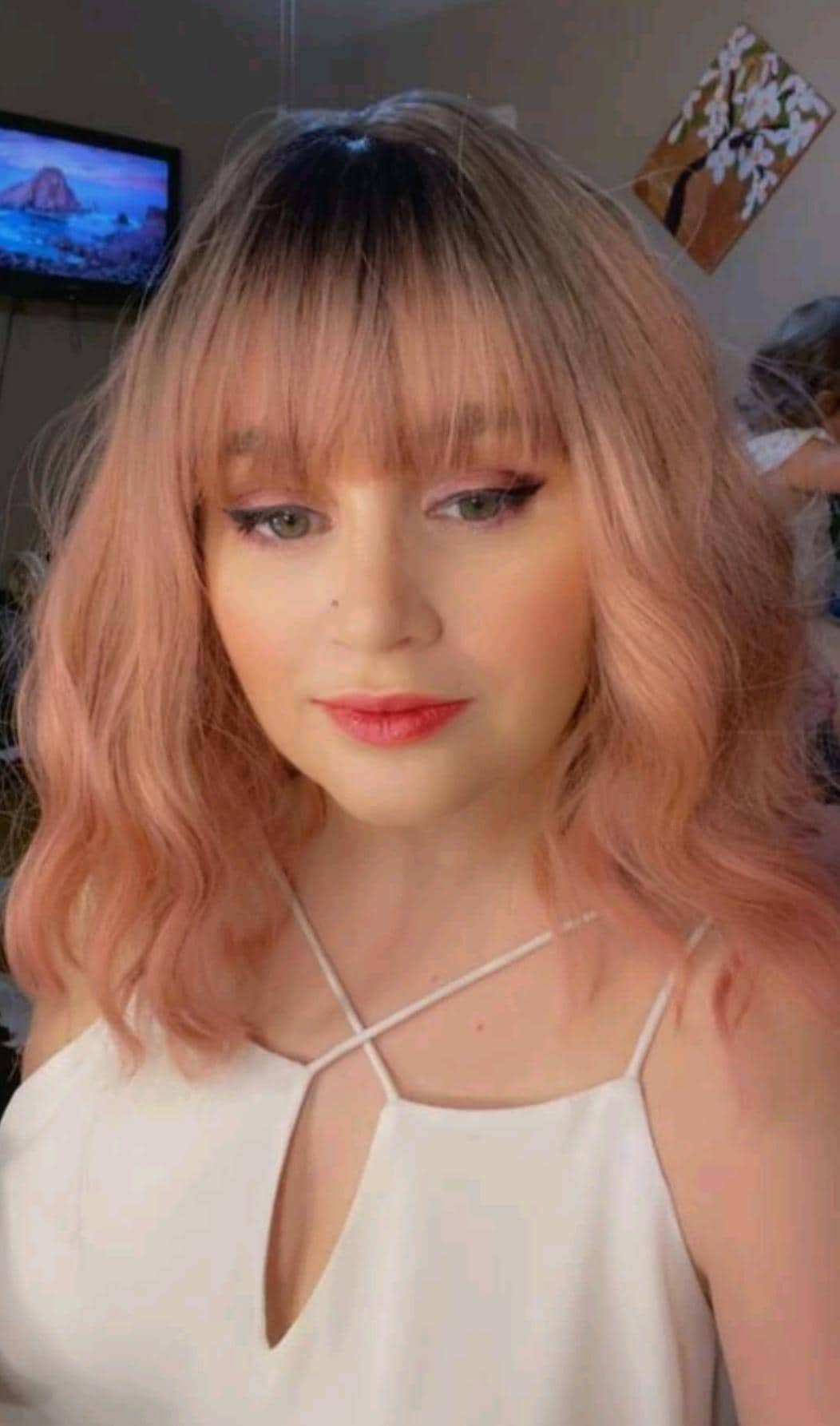 Short wavy pink synthetic wig with dark roots and bangs
