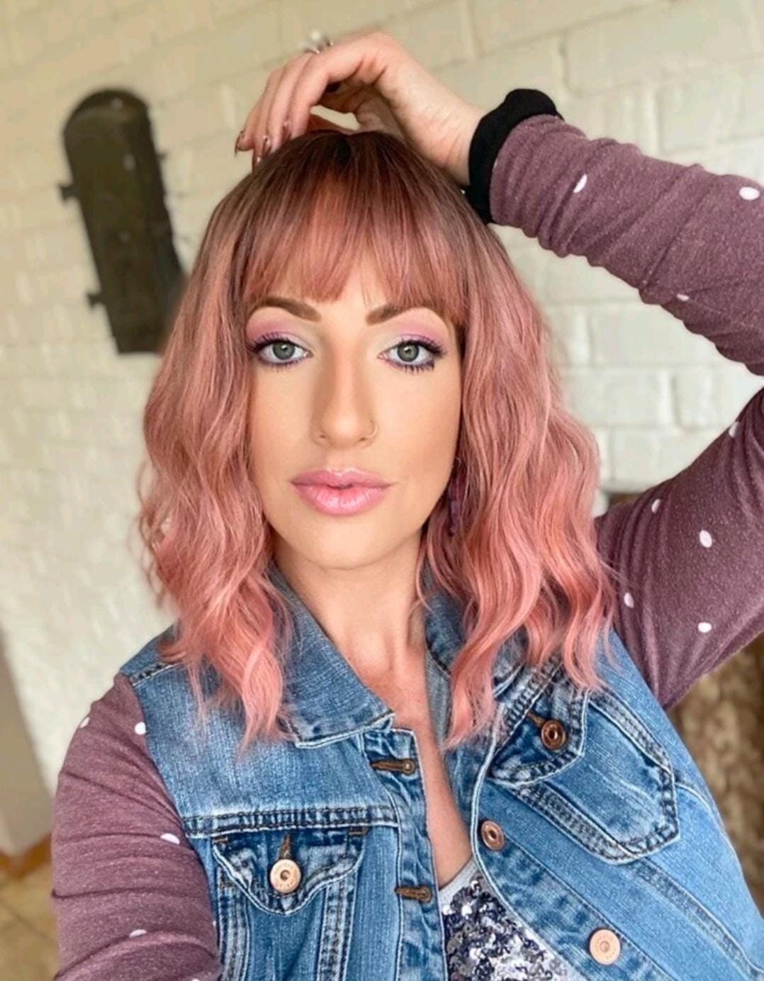 Short wavy pink synthetic wig with dark roots and bangs