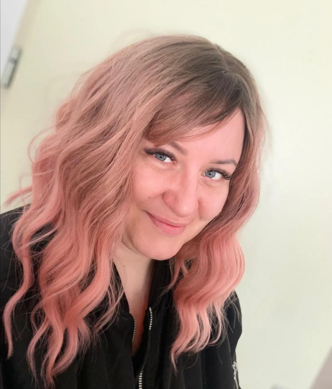 Short wavy pink synthetic wig with dark roots and bangs