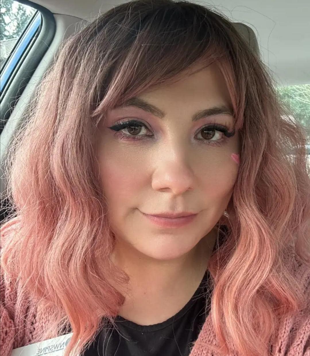 Short wavy pink synthetic wig with dark roots and bangs