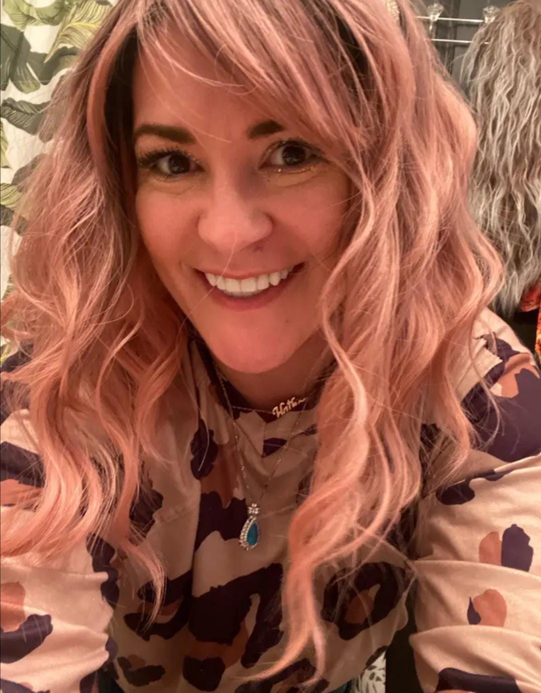 Short wavy pink synthetic wig with dark roots and bangs